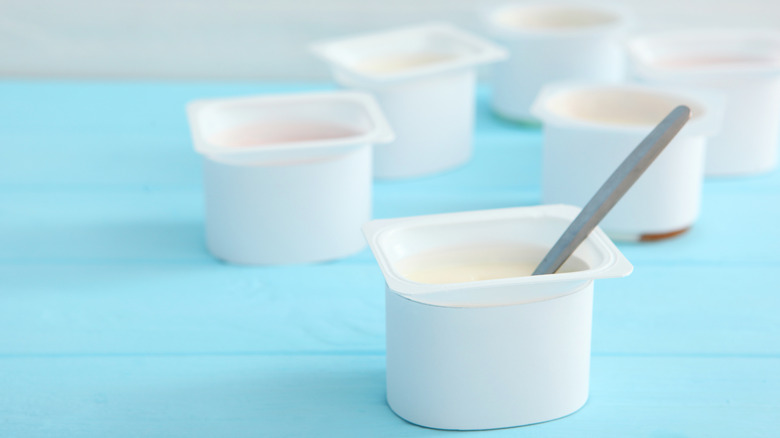 Open containers of yogurt on blue table