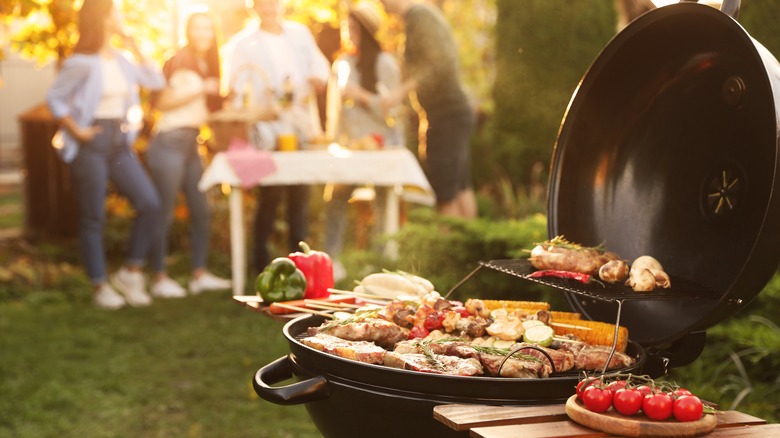 Grilling meats and vegetables in backyard