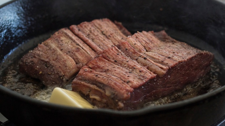 Close-up of two pan-seared ribeye cap steaks with butter