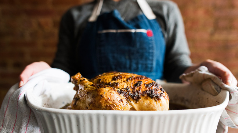 holding roasting pan with chicken