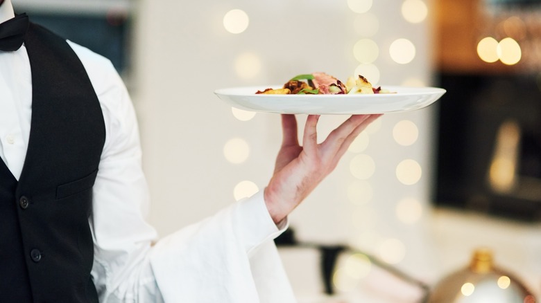 Restaurant server holding plate of food